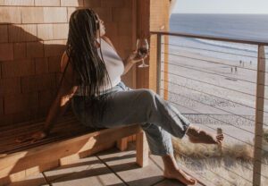 Raising a glass of wine, balcony view of beach